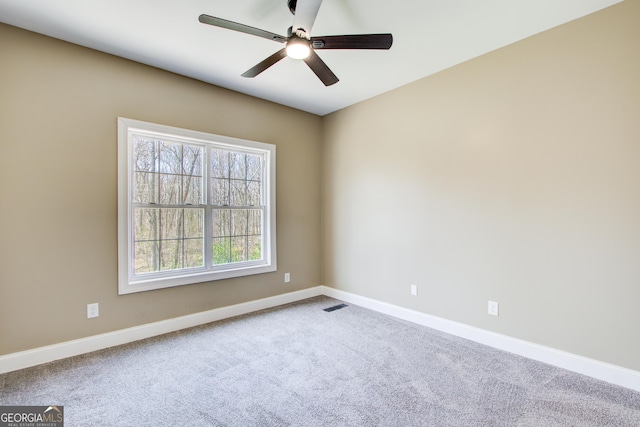 unfurnished room with a ceiling fan, carpet, visible vents, and baseboards