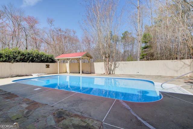 view of swimming pool with a fenced in pool, a fenced backyard, a patio, and a diving board