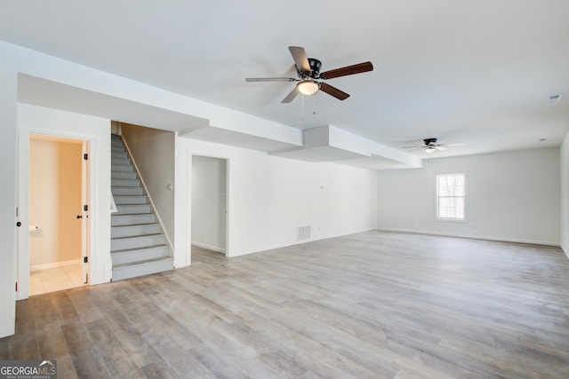 interior space featuring visible vents, ceiling fan, wood finished floors, baseboards, and stairs