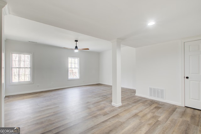 unfurnished room with baseboards, a ceiling fan, visible vents, and light wood-style floors