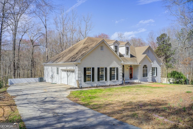 view of front of home with driveway, central air condition unit, an attached garage, and a front yard