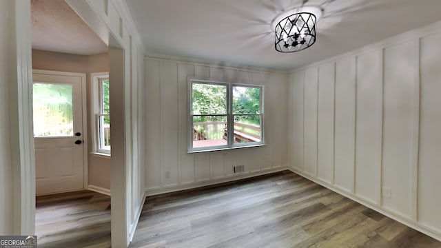 unfurnished dining area with a notable chandelier and light hardwood / wood-style floors