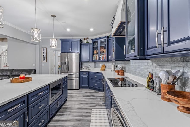 kitchen with backsplash, blue cabinetry, pendant lighting, custom range hood, and stainless steel appliances