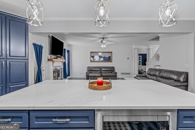 kitchen with light stone counters, crown molding, wine cooler, and blue cabinets