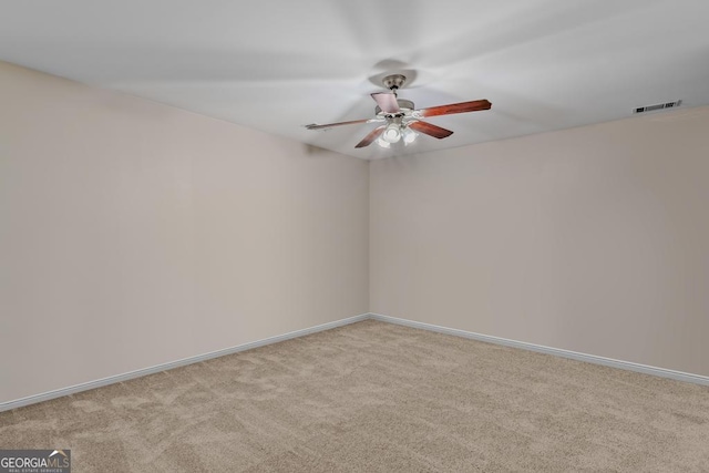 carpeted spare room featuring ceiling fan