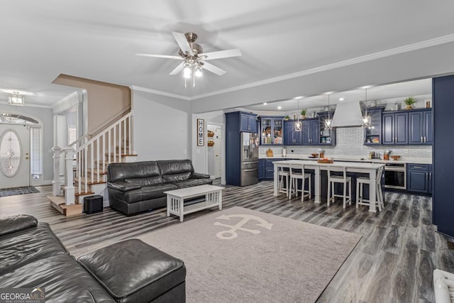 living room featuring ceiling fan, crown molding, and wood-type flooring