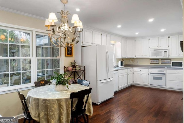 kitchen with white appliances, pendant lighting, dark wood-type flooring, white cabinets, and ornamental molding