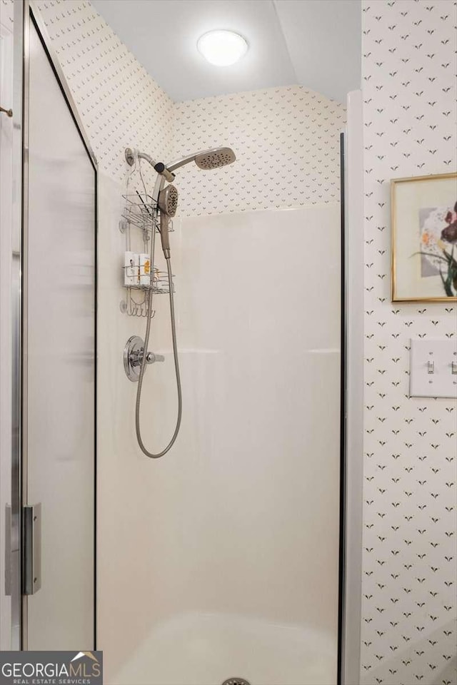 bathroom featuring lofted ceiling and walk in shower