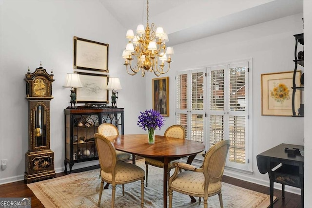 dining space with hardwood / wood-style flooring, a chandelier, and vaulted ceiling