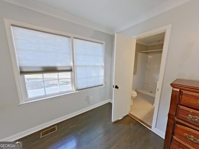 unfurnished bedroom featuring dark wood-type flooring and connected bathroom