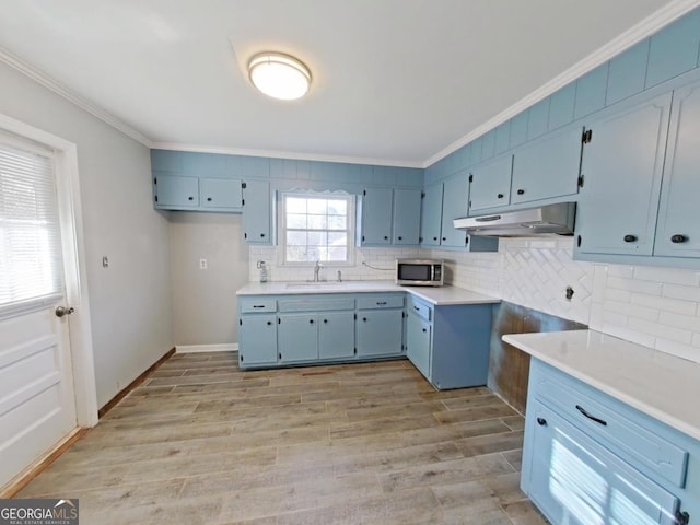 kitchen featuring ornamental molding, decorative backsplash, sink, and light hardwood / wood-style flooring