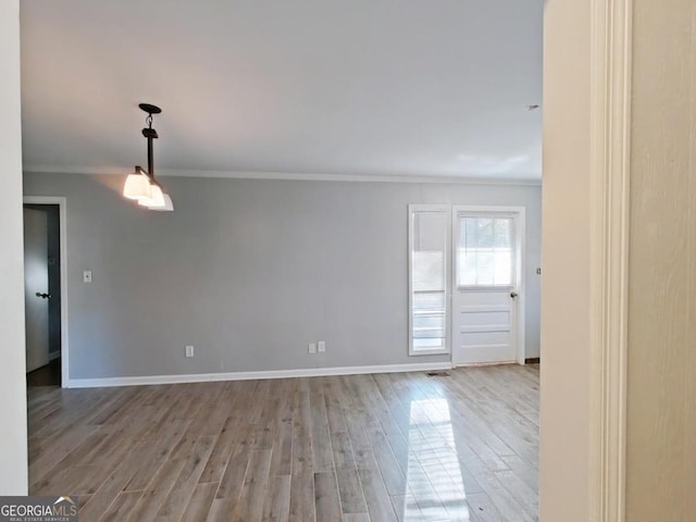 spare room featuring ornamental molding and hardwood / wood-style floors