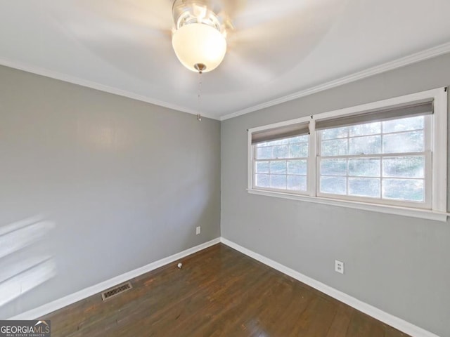 spare room with ornamental molding, dark wood-type flooring, and a healthy amount of sunlight