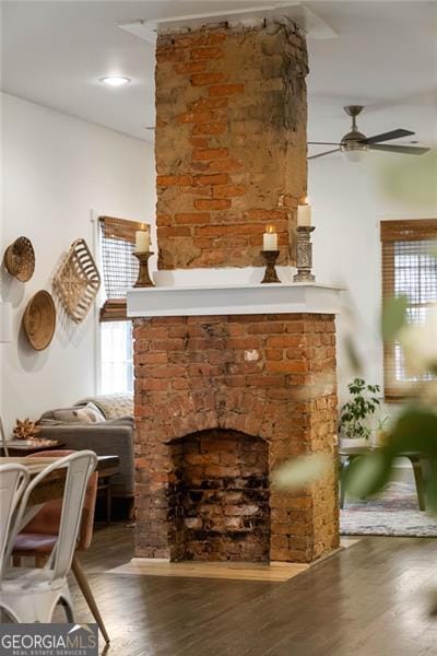 interior space featuring dark wood-style floors, ceiling fan, and a fireplace