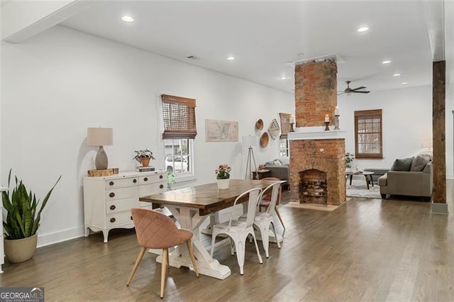 dining area featuring ceiling fan, a fireplace, dark wood finished floors, and recessed lighting