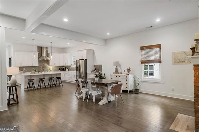 dining room featuring dark wood-type flooring, recessed lighting, beam ceiling, and baseboards