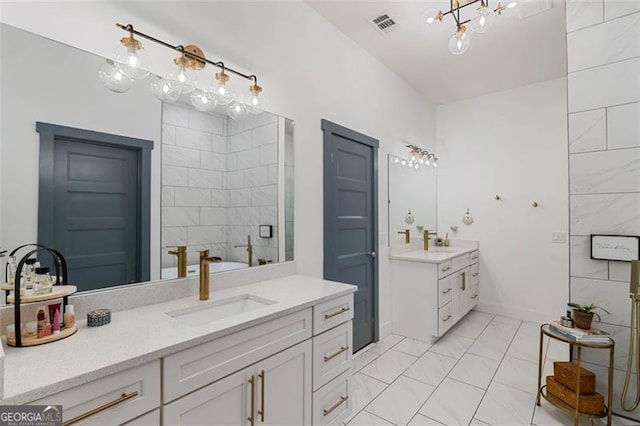 full bathroom with marble finish floor, two vanities, a sink, and visible vents