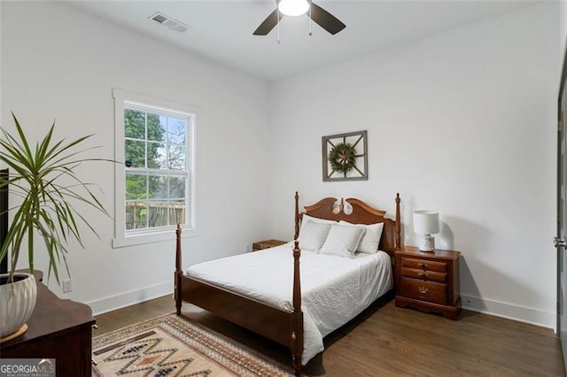 bedroom with visible vents, dark wood finished floors, and baseboards