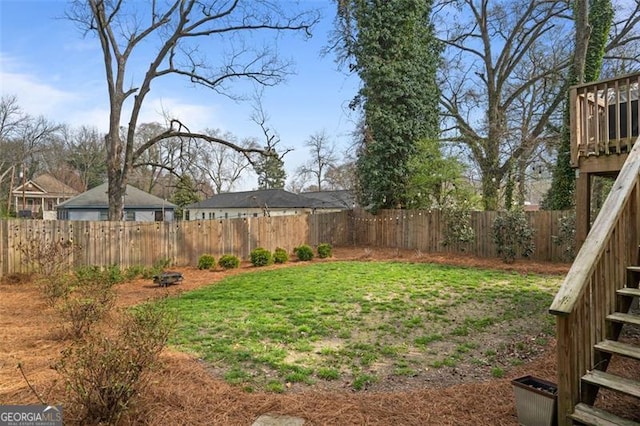 view of yard featuring stairs and a fenced backyard