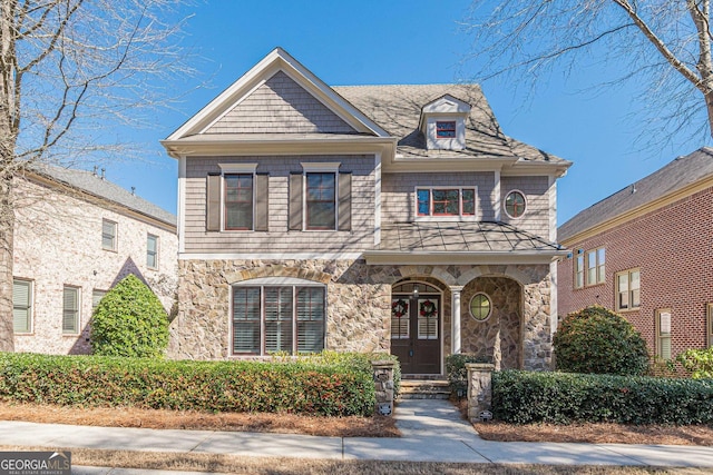 view of front of home featuring stone siding and french doors