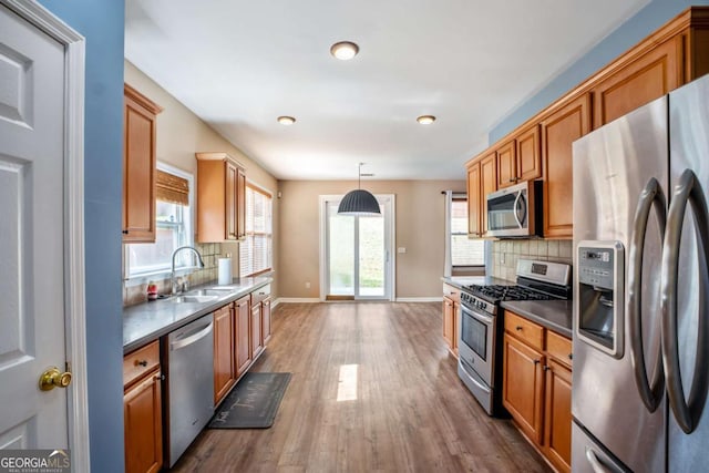 6498 Stonelake Pl SW, Atlanta, GA 30331 - kitchen with stainless steel appliances, wood finished floors, backsplash, a sink, and baseboards