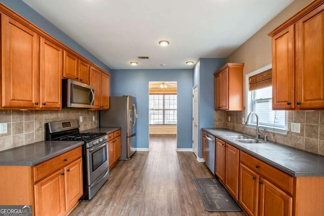 6498 Stonelake Pl SW, Atlanta, GA 30331 - kitchen featuring appliances with stainless steel finishes, a sink, dark countertops, baseboards, and light wood-style floors