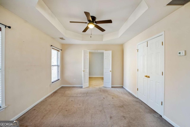 6498 Stonelake Pl SW, Atlanta, GA 30331 - unfurnished bedroom featuring a tray ceiling, carpet flooring, baseboards, a ceiling fan, and a closet