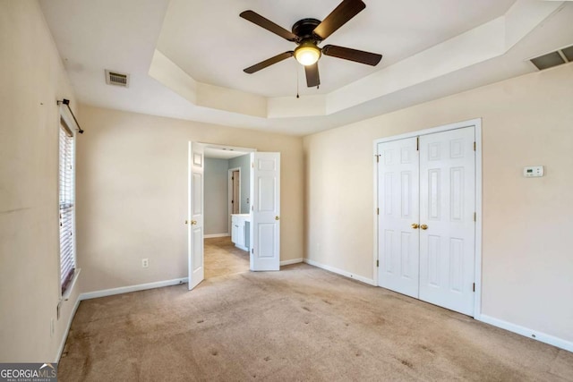 6498 Stonelake Pl SW, Atlanta, GA 30331 - unfurnished bedroom featuring a tray ceiling, baseboards, carpet floors, and a closet