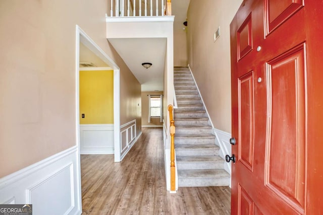 6498 Stonelake Pl SW, Atlanta, GA 30331 - foyer featuring stairs, wood finished floors, wainscoting, a decorative wall, and a high ceiling