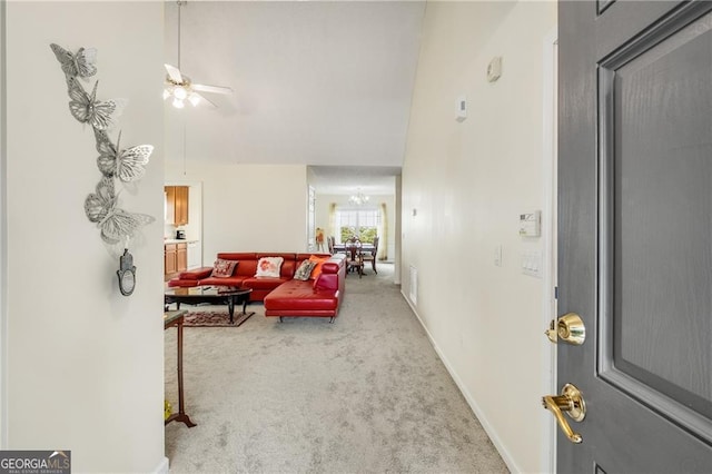 interior space with high vaulted ceiling and ceiling fan with notable chandelier