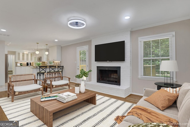 2542 Maclaren, Dunwoody, GA 30360 - living room featuring a fireplace, ornamental molding, recessed lighting, baseboards, and light wood-style floors