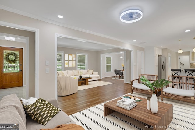 living room with recessed lighting, crown molding, light wood-style flooring, and baseboards