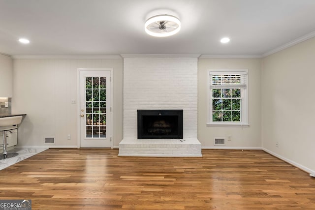 2542 Maclaren, Dunwoody, GA 30360 - unfurnished living room with crown molding, wood finished floors, a brick fireplace, baseboards, and recessed lighting