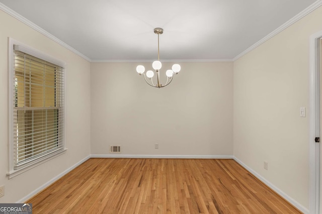 spare room with crown molding, visible vents, a chandelier, light wood-type flooring, and baseboards