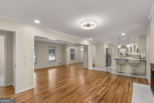 2542 Maclaren, Dunwoody, GA 30360 - unfurnished living room featuring light wood-style flooring, ornamental molding, baseboards, and recessed lighting