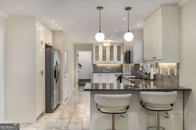 kitchen featuring decorative light fixtures, glass insert cabinets, white cabinets, a peninsula, and stainless steel fridge with ice dispenser