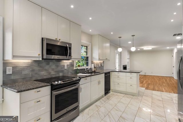 kitchen featuring visible vents, appliances with stainless steel finishes, a peninsula, hanging light fixtures, and backsplash