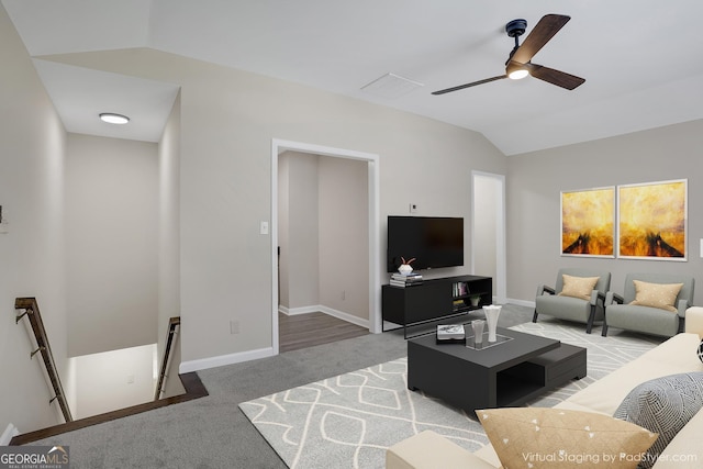 living room with vaulted ceiling, carpet floors, a ceiling fan, and baseboards