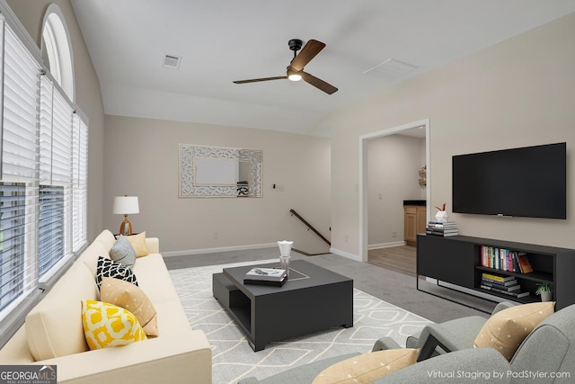 living room with light colored carpet, ceiling fan, and baseboards