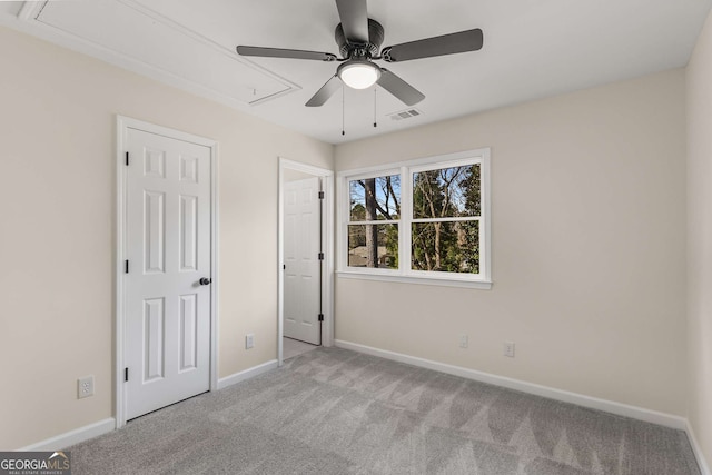 unfurnished bedroom with attic access, visible vents, light carpet, and baseboards