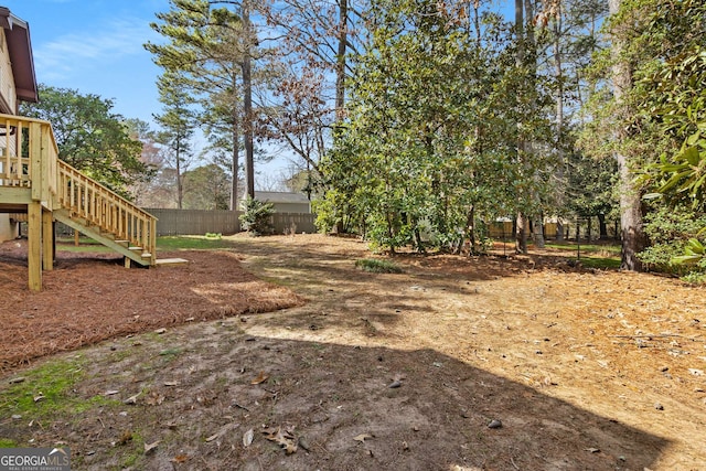 view of yard featuring stairs and fence