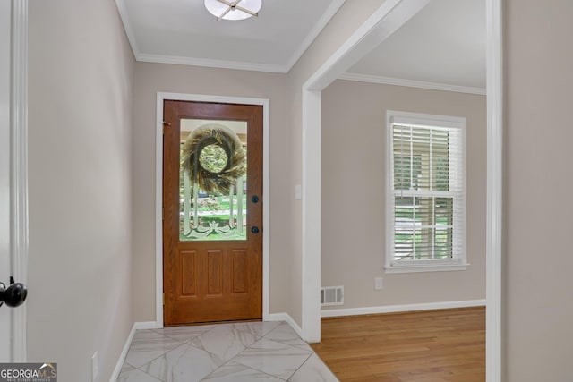 entrance foyer featuring visible vents, crown molding, and baseboards