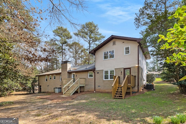 back of property featuring brick siding, a yard, a chimney, central AC unit, and crawl space