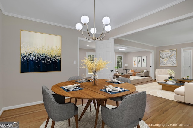 dining area with crown molding, a notable chandelier, and wood finished floors