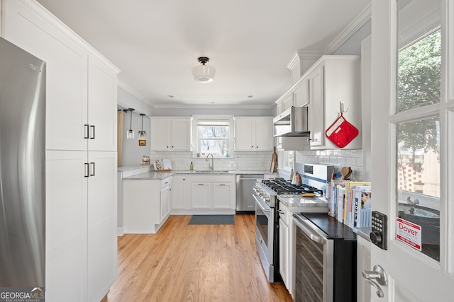 kitchen featuring white cabinets, dishwashing machine, high end stove, fridge, and a sink