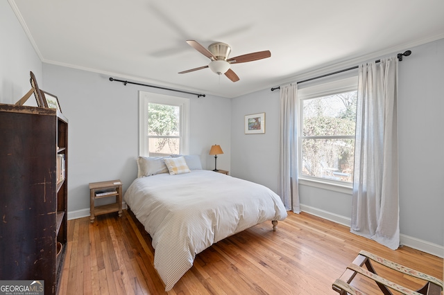 bedroom featuring light wood-type flooring, baseboards, and crown molding