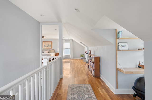 additional living space featuring lofted ceiling, light wood-style floors, and baseboards