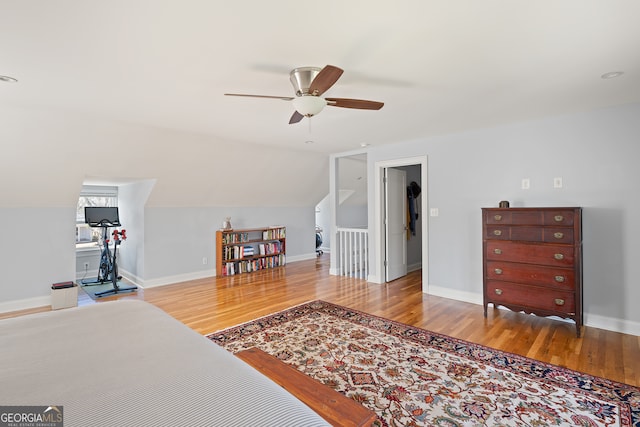 interior space featuring lofted ceiling, ceiling fan, wood finished floors, and baseboards