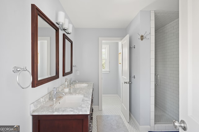 full bath featuring a sink, a shower stall, baseboards, and double vanity