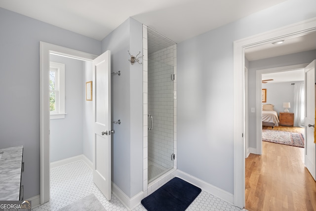 ensuite bathroom with a shower stall, baseboards, and ensuite bathroom